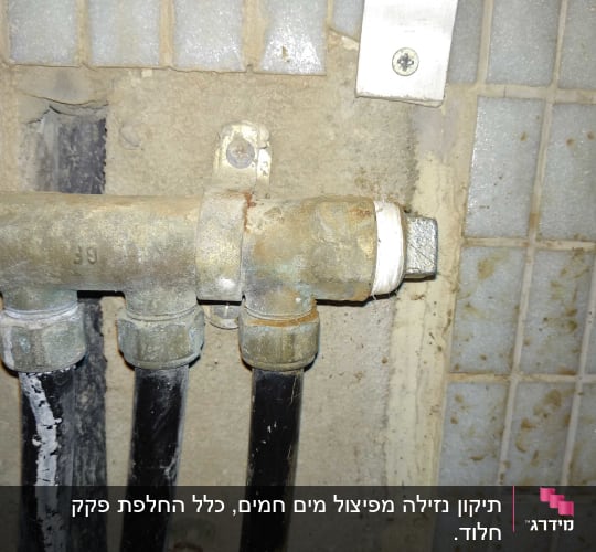 צינורות מתכת עם חיבורים על קיר